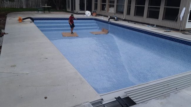 Pool liner being added to backyard pool