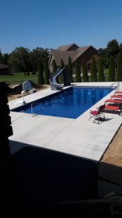 rectangular pool in backyard with slide