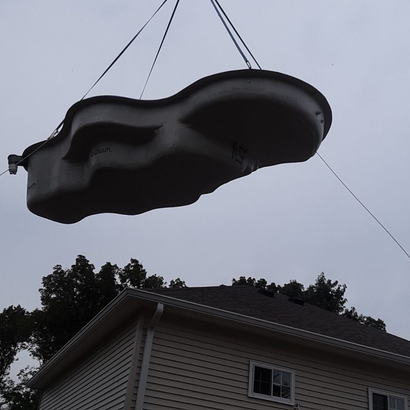 Pool form being lowered into backyard